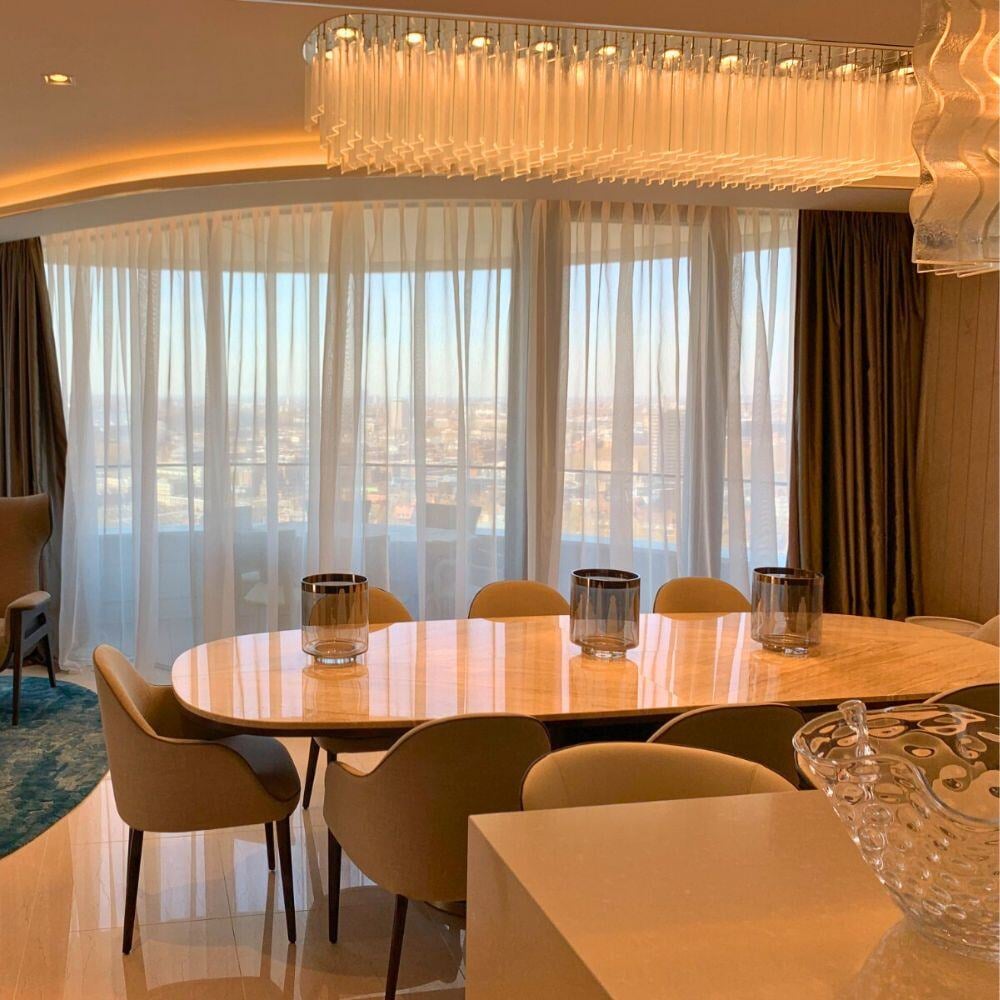 Dining room with panoramic city views and custom light fixture.