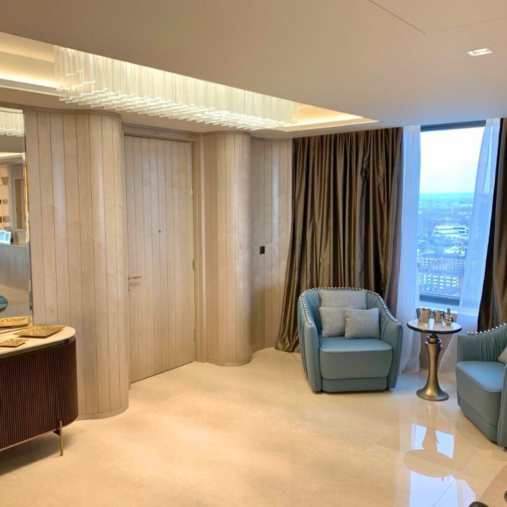 Stylish entrance with bespoke wall panelling and modern armchairs
