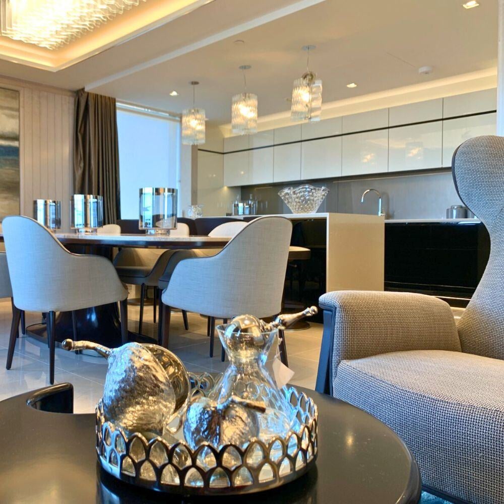 Low-angle view of luxury penthouse kitchen with pendant lighting and marble dining table.