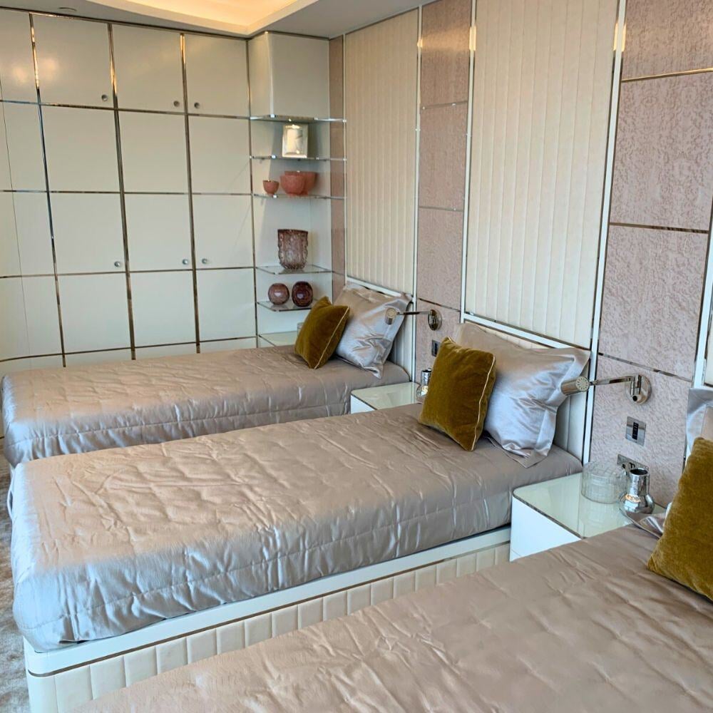 Triple bedroom with bespoke cabinetry and velvet pillows in Albert Embankment penthouse