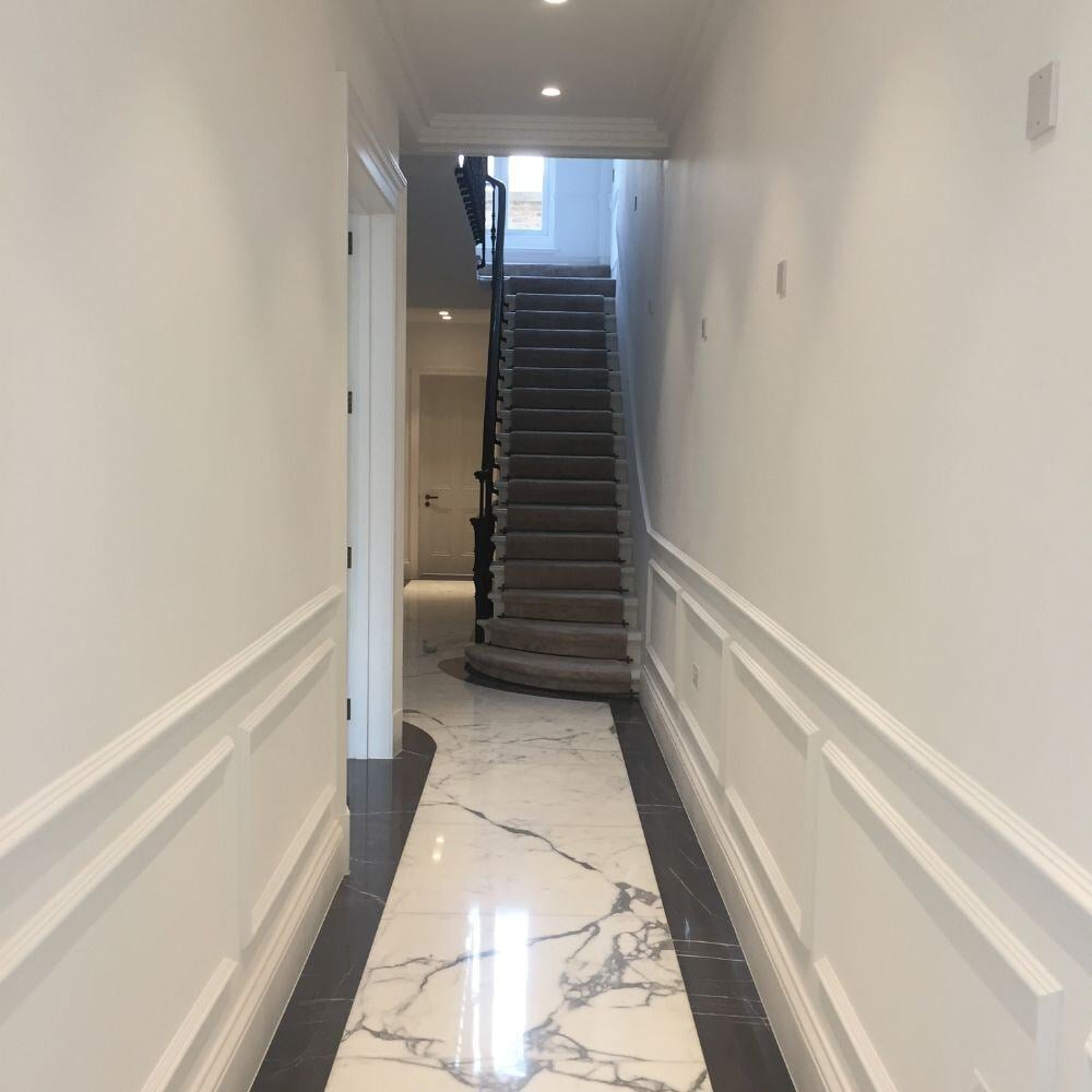 Elegant entrance hallway with marble flooring and period wall panelling in a luxury Belgravia townhouse renovation.