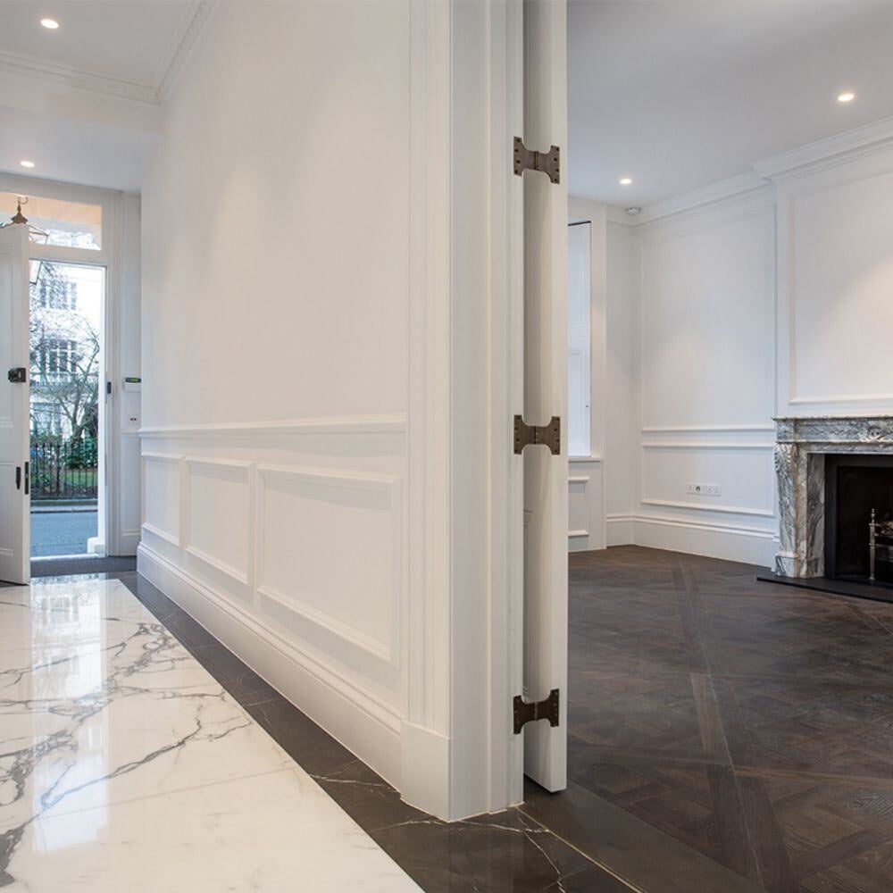 Refurbished Belgravia reception room with original fireplace, dark herringbone parquet, and marble skirting.