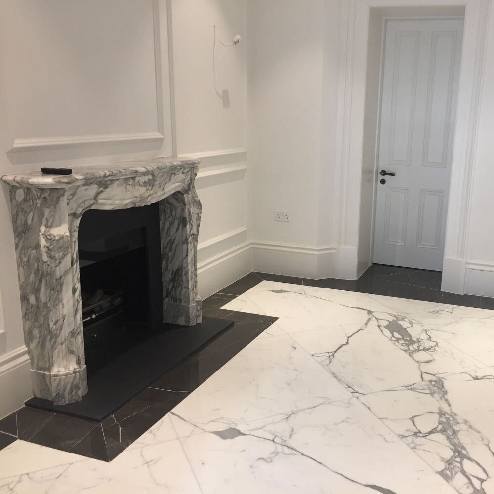 Luxury Belgravia reception room featuring a carved marble fireplace and polished contrasting marble flooring.