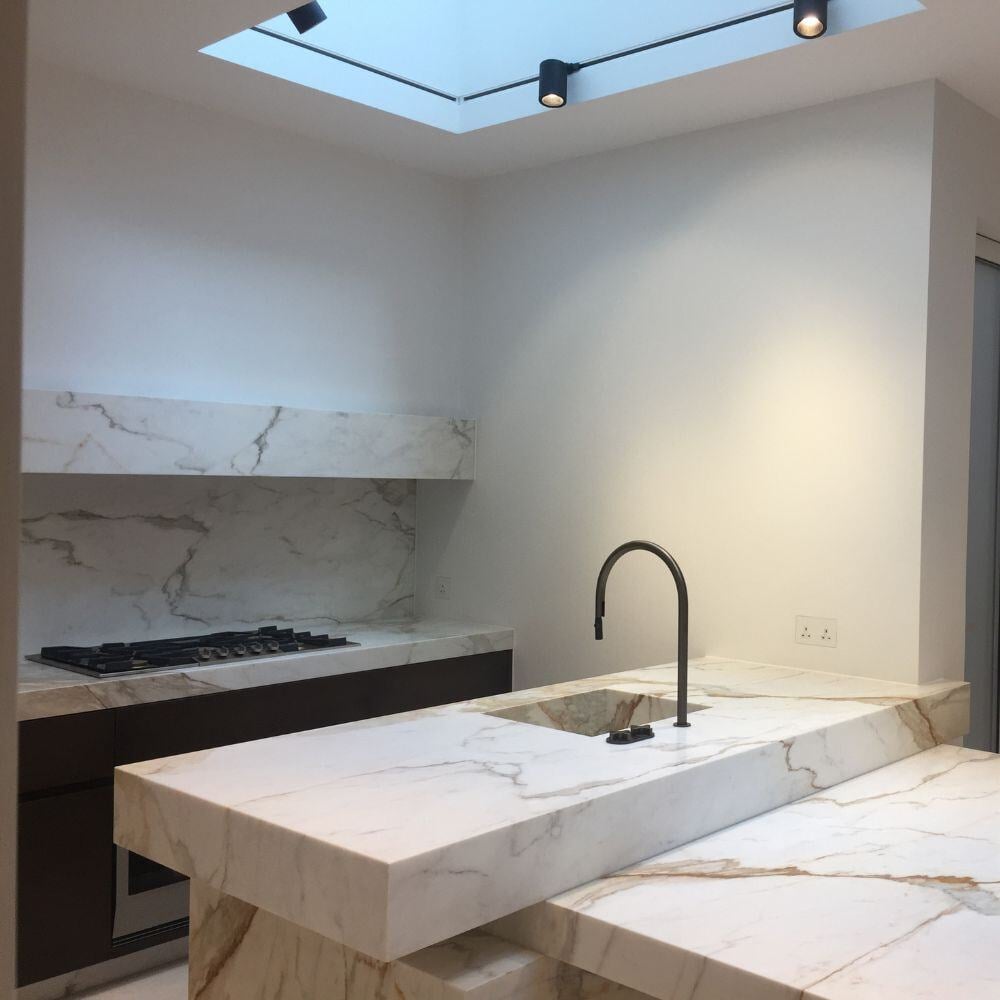 Elegant marble worktop with cooker and backsplash in a high-end kitchen fit-out in Belgravia, London.