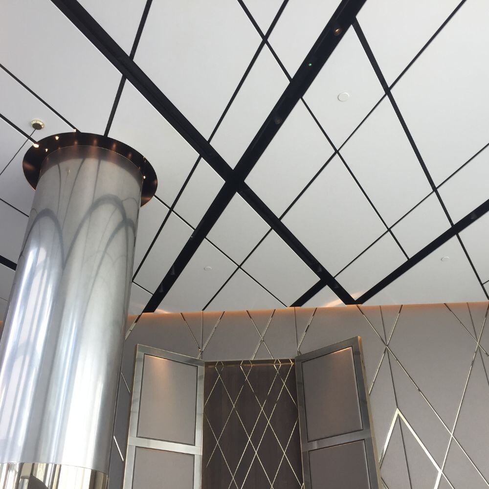 Ceiling detail of Chelsea Waterfront lobby featuring geometric panelling and ambient lighting.