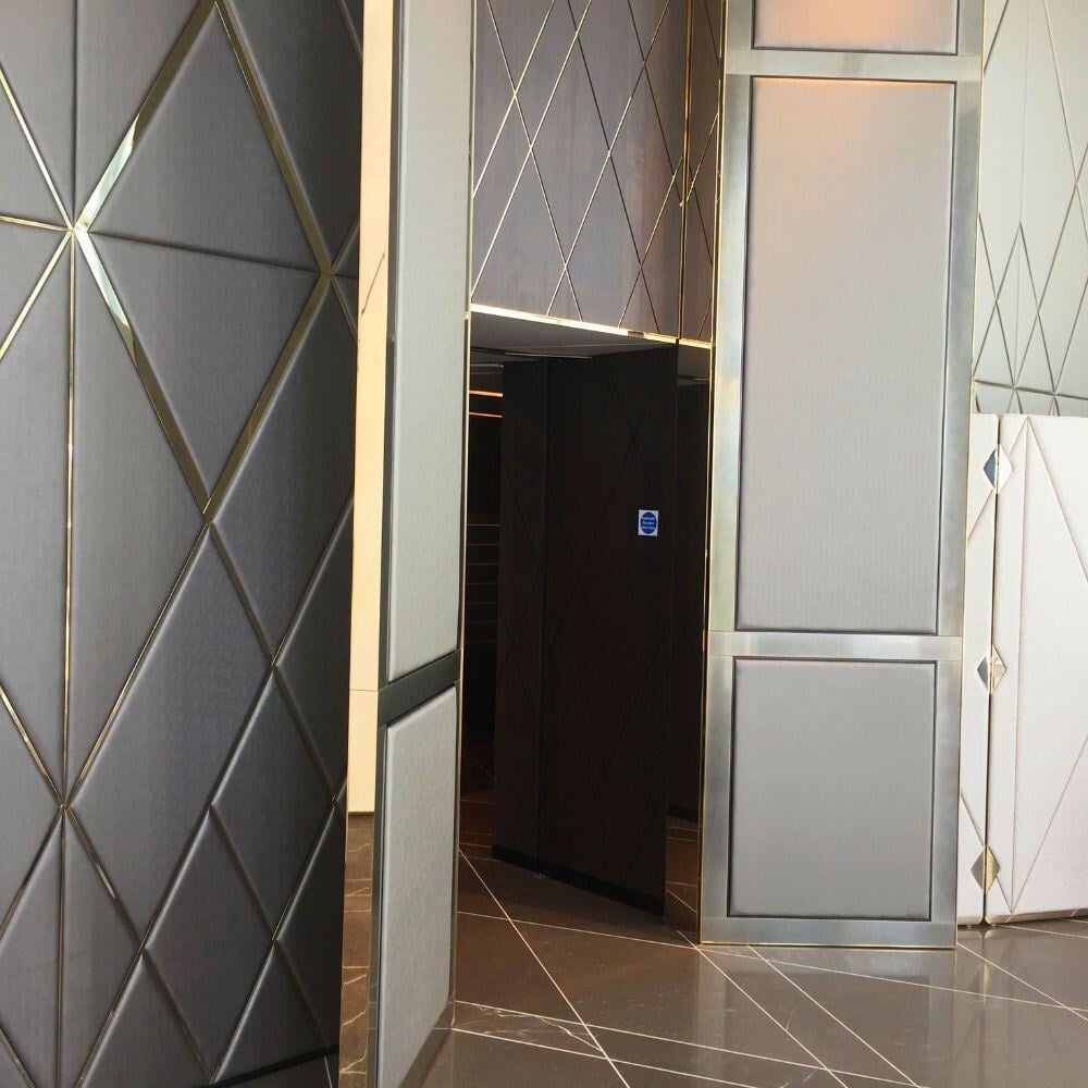 Tall grand doors of Chelsea Waterfront with gold trim and diamond-patterned panelling.