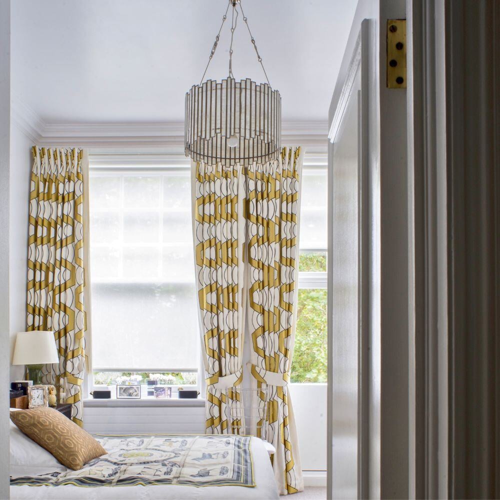 Contemporary bedroom with patterned curtains, metallic chandelier, and mid-century decor in Evelyn Gardens.