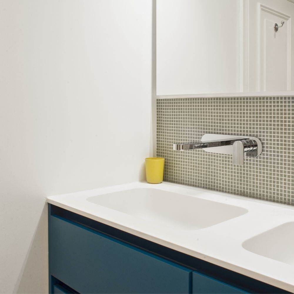 Modern double vanity with mosaic backsplash and built-in storage in minimalist London bathroom renovation.