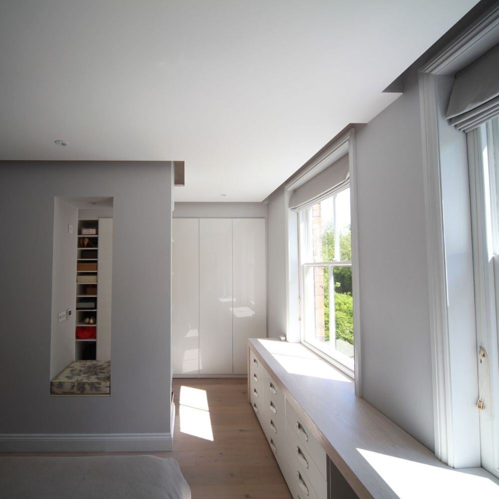 Bright bedroom with built-in storage and large windows bringing in natural light.