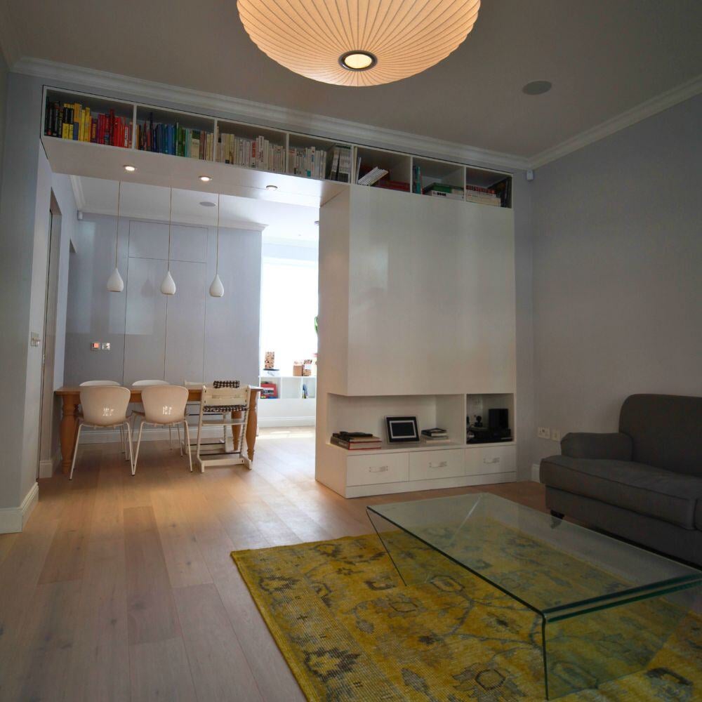 Living area featuring integrated shelving, storage, and pendant lighting.