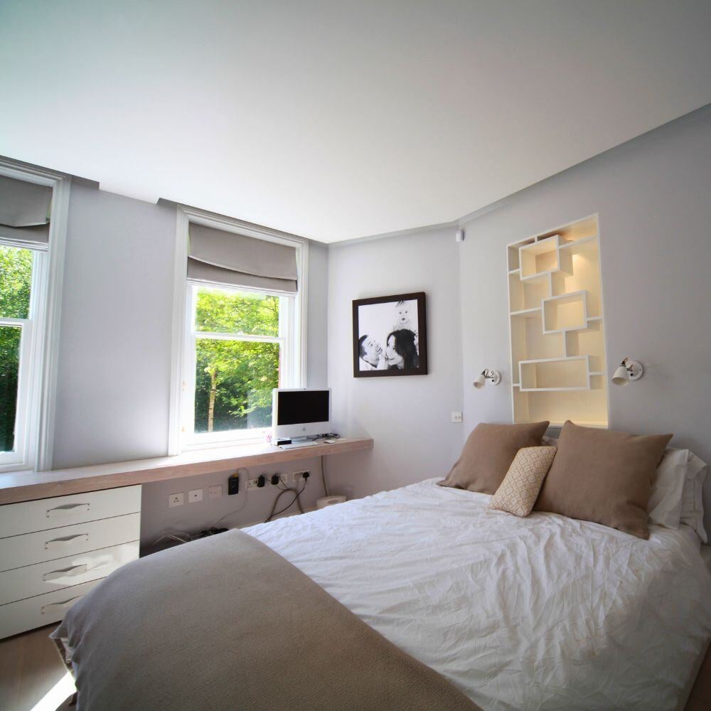 Modern bedroom with ambient soft lighting and custom shelving unit.