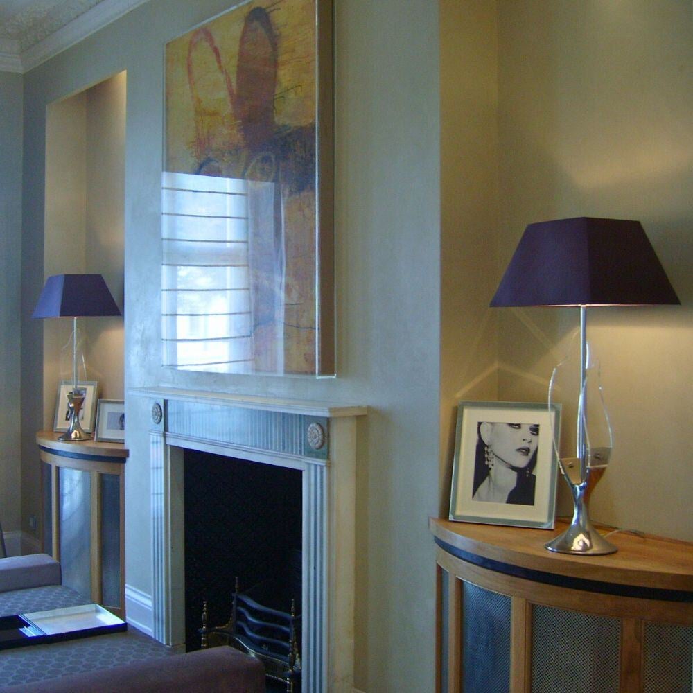 Refined living area with a traditional fireplace, abstract art, and designer lighting.