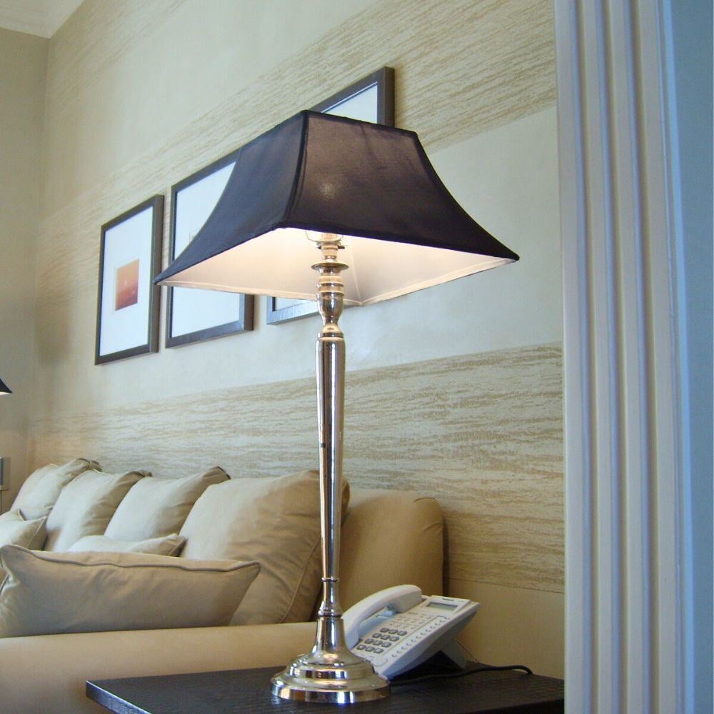Close-up of a silver table lamp beside a neutral sofa in Walton Place living room.